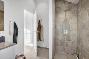 un bagno con doccia con porta in vetro di BL1427-Blokhus-Ovesensvej-9 a Blokhus Altre 33 foto