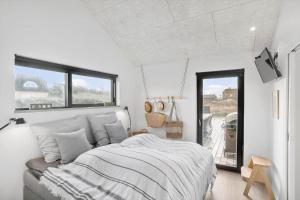 una camera da letto bianca con un letto e una finestra di BL1427-Blokhus-Ovesensvej-9 a Blokhus
