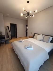 a bedroom with a large white bed with towels on it at First Line - Dzintaru prospekts Apartment in Jūrmala
