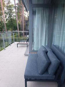 a blue couch sitting outside of a house at First Line - Dzintaru prospekts Apartment in Jūrmala
