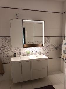 a bathroom with a sink and a mirror at First Line - Dzintaru prospekts Apartment in Jūrmala +16 photos