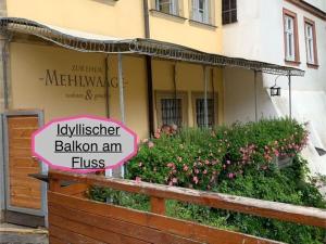 a sign on a fence in front of a house at Gästehaus zur ehemaligen Mehlwaage wohnen und genießen in Bamberg