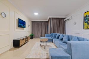 a living room with a blue couch and a tv at Blue Ivy in Lagos