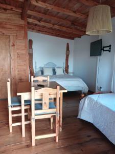 a bedroom with a table and chairs and a bed at La Cabaña de Sofi in Tandil