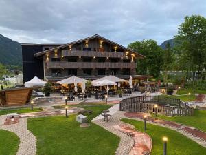 a large building with tables and chairs in front of it at Frutigresort in Frutigen