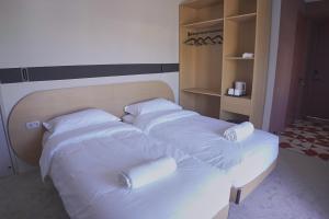 two beds in a room with white sheets and pillows at Nomad Camp Hotel in Kaji-Say