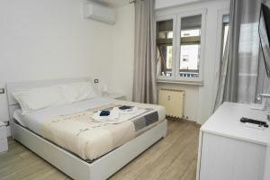 a white bedroom with a bed and a window at IL BACIO Guest House - Affitti Brevi Italia in Perugia