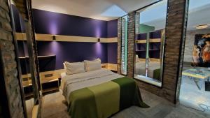 a bedroom with purple walls and a bed with a mirror at ANKA RESİDENCE KIZıLAY in Ankara