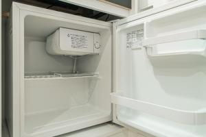 東京にあるTokyo Ueno Mia Hotelのドアが開いた冷蔵庫の中に電子レンジが入っている +70枚の写真