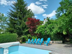 a group of blue chairs next to a swimming pool at Villa 3 chambres à Saint-Cirgues-de-Malbert avec piscine in Saint-Cirgues-de-Malbert