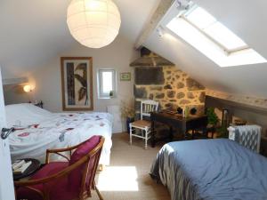 a bedroom with two beds and a desk in a attic at Villa 3 chambres à Saint-Cirgues-de-Malbert avec piscine in Saint-Cirgues-de-Malbert