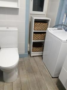 a bathroom with a toilet and a shelf with baskets at Villa 3 chambres à Saint-Cirgues-de-Malbert avec piscine in Saint-Cirgues-de-Malbert +44 photos