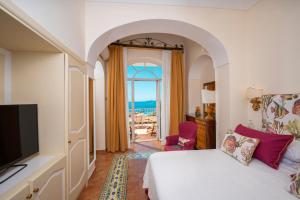 a bedroom with a bed and a view of the ocean at Hotel Buca Di Bacco in Positano