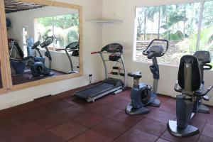 a gym with several exercise bikes and a mirror at Eleven Pearl Boutique Hotel & Spa in Diani Beach