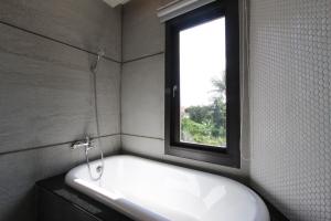 bagno con vasca e finestra di Muguang Inn a Città Vecchia di Hengchun