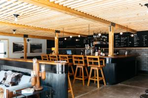 a bar in a restaurant with wooden ceilings and wooden stools at The Coachman Hotel in South Lake Tahoe