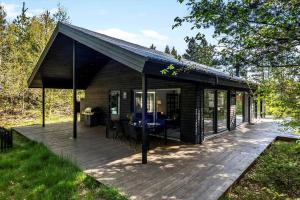 Cabaña con terraza con mesa y sillas en BL1266-Pandrup-Rodhusparken-58, en Pandrup