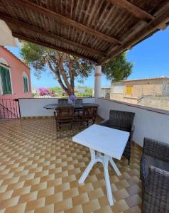 a patio with a white table and chairs and a tree at Dimora del Verde in Forio d'Ischia +23 photos