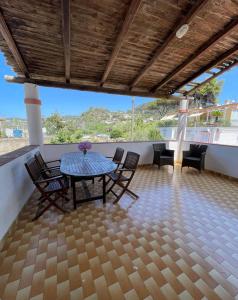 a patio with a table and chairs on a roof at Dimora del Verde in Ischia