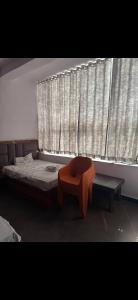 a bedroom with a bed and a bench in front of a window at Hotel IC TOWER in Noida