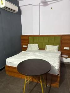 a bedroom with a bed with a table next to it at Hotel IC TOWER in Noida