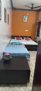 a bedroom with two beds and a table at Atithi Home Stay- Studio Room in Udaipur
