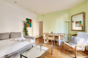 un salon avec un canapé et une table dans l'établissement Lovely 2BR Flat with balcony - Eiffel Tower & Seine, à Paris