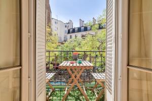 une fenêtre ouverte avec une table et des chaises sur un balcon dans l'établissement Lovely 2BR Flat with balcony - Eiffel Tower & Seine, à Paris 7 autres photos