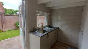 a kitchen with a sink and a window at Camino in Vrouwenpolder +26 photos