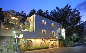 a building on the side of a street at night at Phoenix Pavilion Hot Spring Hotel in Taipei