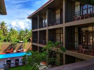 ネゴンボにあるHotel Waves Negomboのスイミングプール付きの建物の外観