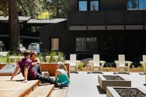 a group of people sitting on a wooden bench at The Coachman Hotel in South Lake Tahoe