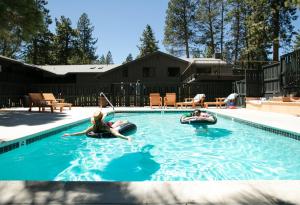 two people in an outdoor swimming pool withotation tubes at The Coachman Hotel in South Lake Tahoe