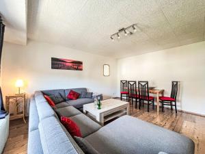 a living room with a couch and a table at Apartment Holiday-Home Nr 1 am Bostalsee by Interhome in Steinberg-Deckenhardt