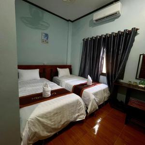 a hotel room with two beds and a window at 万荣微笑酒店 in Vang Vieng