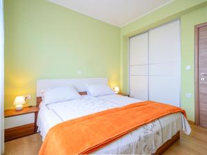 a bedroom with a large bed with an orange blanket at Apartment Marijo by Interhome in Matulji