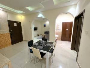 a dining room and living room with a table and chairs at Masaf apartment in Al Mithnab