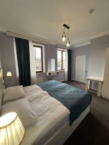 a bedroom with a large bed and two windows at Resort Hotel Baku in Baku