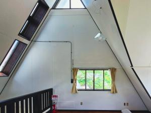 a room with a large window in a attic at LOGIN OKINAWA -mayonaka- in Onna
