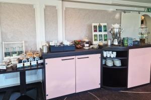 een koffieshop met twee tafels en een toonbank bij Garner Hotel Hamburg - Wandsbek Marktplatz by IHG in Hamburg