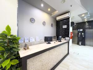 a lobby with a reception desk with a clock on the wall at Masaf apartment in Al Mithnab