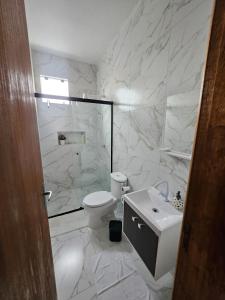 a bathroom with a shower and a toilet and a sink at Ótimo Apartamento in São José
