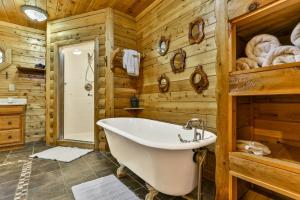 ein Badezimmer mit Badewanne und Holzwänden in der Unterkunft DANCING BEARS CABIN - Secluded 3-Bedroom, 3.5-Bath Luxury Cabin with Hot Tub in Mineral Bluff + 64 Fotos