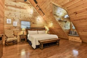 ein Schlafzimmer mit einem Bett in einer Holzhütte in der Unterkunft DANCING BEARS CABIN - Secluded 3-Bedroom, 3.5-Bath Luxury Cabin with Hot Tub in Mineral Bluff