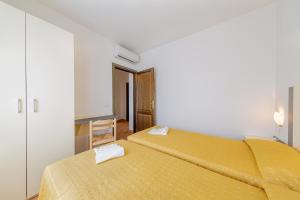two beds in a room with yellow sheets at Residenza Le Farfalle in Tergu +46 photos