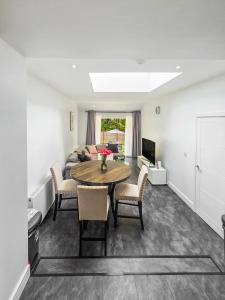 a living room with a table and chairs and a couch at Near Wembley Ground Floor Flat with Garden & Parking in The Hyde