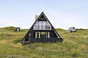 a black triangular house in a field with windows at BL1193-Pandrup-Narhvalen-14 in Pandrup