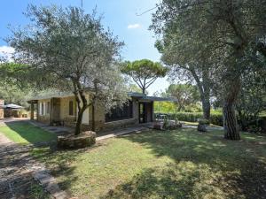 ein Haus inmitten eines Hofes mit Bäumen in der Unterkunft Holiday Home Villa Anna by Interhome in Castiglione della Pescaia + 38 Fotos