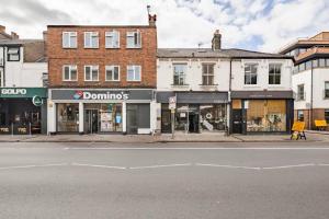 a street with shops on the side of the road at Stunning 2 Bedroom Flat with Charming Patio in Cambridge