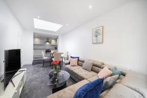 a living room with a couch and a table at Near Wembley Ground Floor Flat with Garden & Parking in The Hyde +20 photos